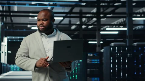 Programmer in data center using laptop, testing equipment failover scenarios Stock Footage 311963185