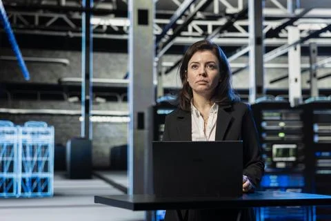 Programmer in data center using laptop, doing brainstorming, Stock Photos