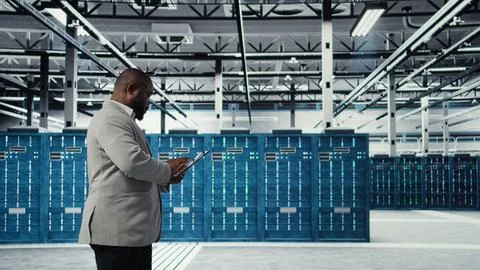 Programmer in data center using tablet to manage software updates Stock Photos