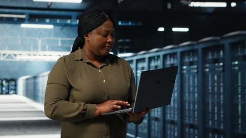 Programmer in data center using tablet to increase workload capacity Foto stock