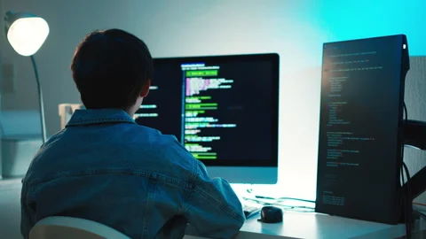 Programmer debugging code on multiple screens for software development and Video stock 313808882