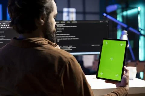 Programmer designing and developing software using green screen tablet Stock Photos