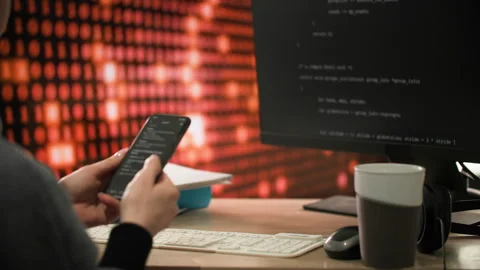 A programmer at desk actively inspecting information into a phone Close-up shot Stock-Footage 312824564