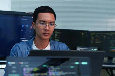 Programmer Developing Digital Software with Code on Multiple Screens Stock Photos