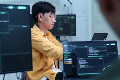 Programmer Developing Software Code Across Multiple Monitors Fotos Stock
