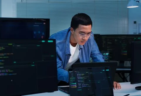 Programmer Developing Software with Code on Multiple Screens Stockfoto's