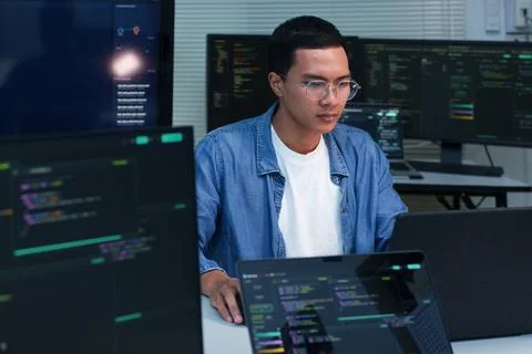Programmer Developing Software with Code on Multiple Screens Stock Photos