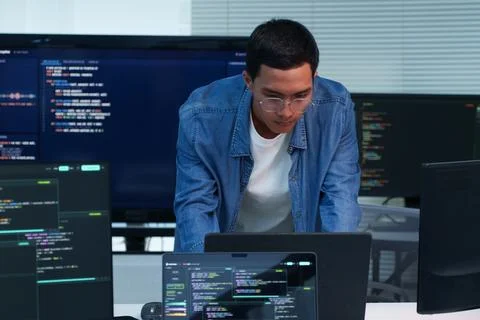 Programmer Developing Software with Code on Multiple Screens Stock Photos