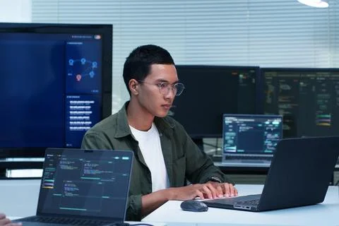Programmer Developing Software Code with Multiple Computer Screens Fotos Stock
