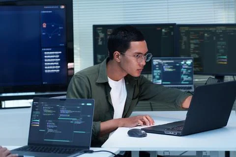 Programmer Developing Software with Code on Multiple Screens Stock Photos