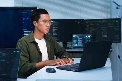 Programmer Developing Software with Laptop and Multiple Monitors Stock Photos
