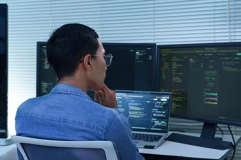 Programmer Developing Software with Multiple Code Screens Stock Photos