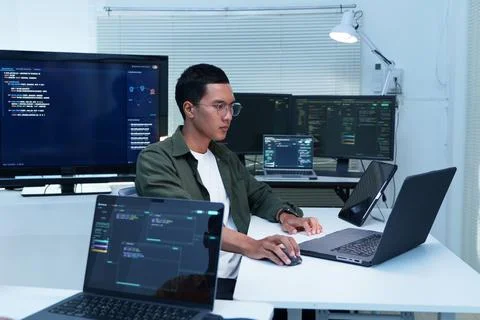 Programmer Developing Software with Multiple Code Screens Stock-Fotos