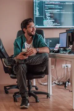 A programmer diligently testing smartphone applications while sitting in their 스톡 사진