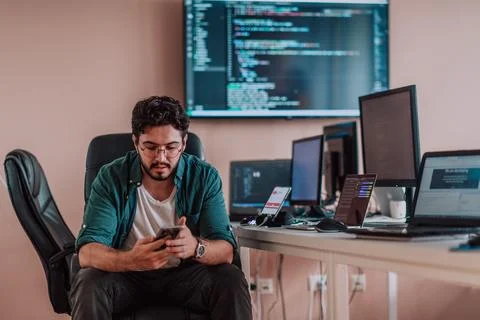 A programmer diligently testing smartphone applications while sitting in their Stockfoto's