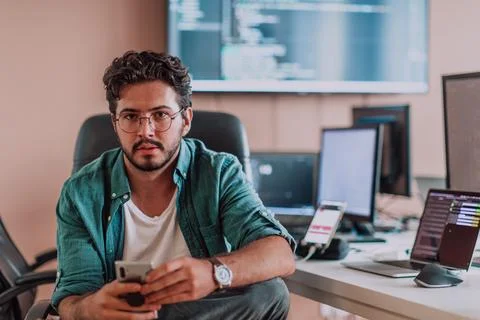 A programmer diligently testing smartphone applications while sitting in their Stockfoto's