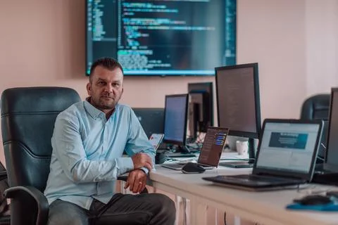 A programmer diligently testing smartphone applications while sitting in their Stockfoto's