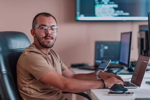 A programmer diligently testing smartphone applications while sitting in their 库存照片