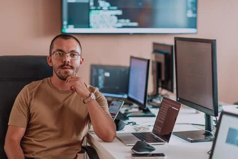 A programmer diligently testing smartphone applications while sitting in their Stockfoto's