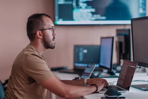 A programmer diligently testing smartphone applications while sitting in their Stockfoto's