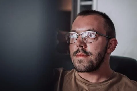 A programmer diligently testing smartphone applications while sitting in their 写真素材