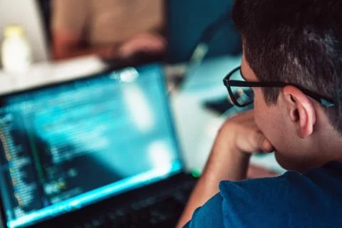 A programmer diligently testing smartphone applications while sitting in their Stockfoto's