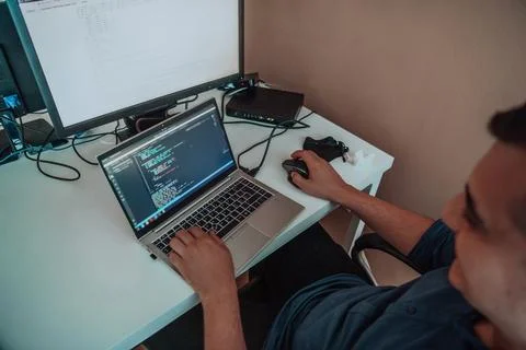 A programmer diligently testing smartphone applications while sitting in their Stockfoto's
