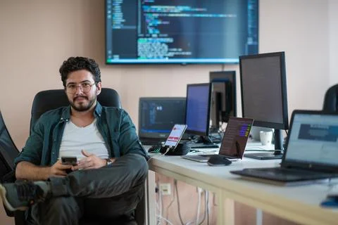 A programmer diligently testing smartphone applications 库存照片