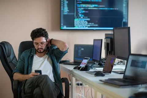 A programmer diligently testing smartphone applications 库存照片