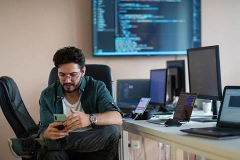 A programmer diligently testing smartphone applications Stock Photos