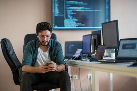 A programmer diligently testing smartphone applications Stock Photos