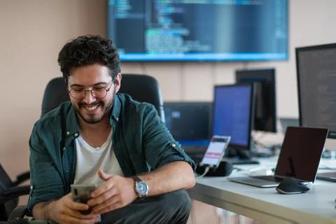 A programmer diligently testing smartphone applications Stock Photos