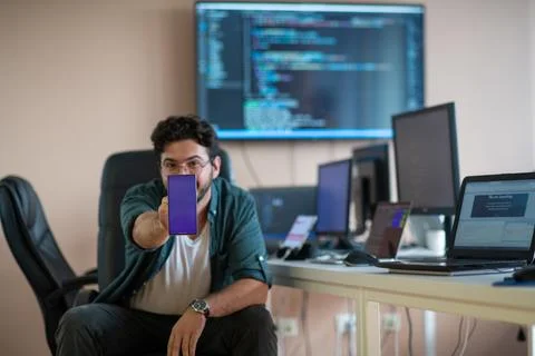 A programmer diligently testing smartphone applications Stock Photos