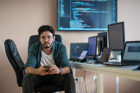 A programmer diligently testing smartphone applications Stock Photos