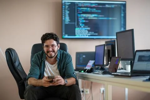A programmer diligently testing smartphone applications 库存照片
