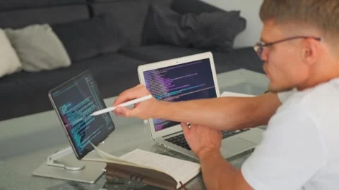 Programmer discusses app development, checking errors on tablet. Stock-Footage 294299295