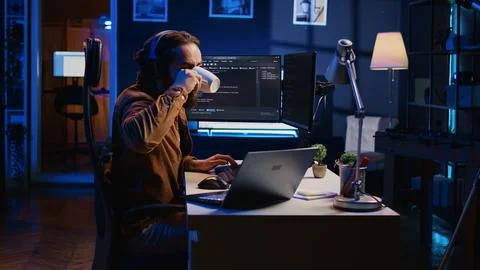 Programmer does multitasking, drinks coffee, listens music Stock Photos