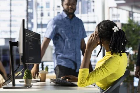 Programmer doing software debugging, asking for help from coworker 스톡 사진