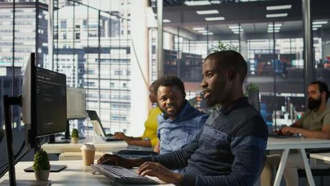 Programmer doing software debugging, asking for help from smiling team leader 스톡 사진