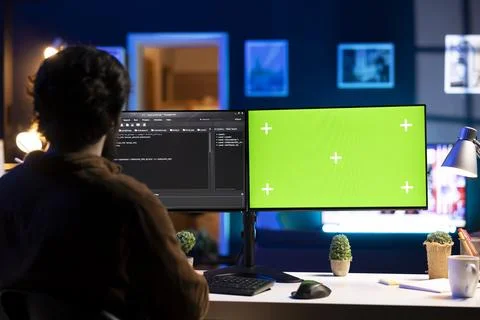 Programmer doing software debugging on green screen PC at home Stock-Fotos