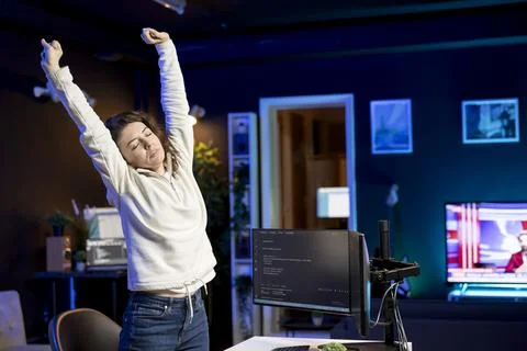 Programmer doing software quality assurance, stretching arms and back 库存照片