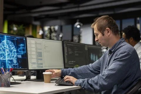 Programmer drinks coffee and uses deep learning in tech startup office 库存照片