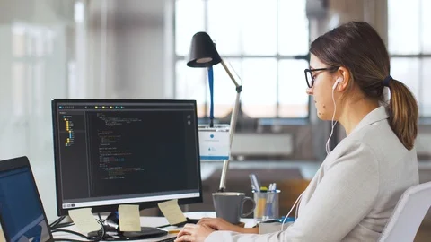 Programmer in earphones working on computer Stock Footage 105417873