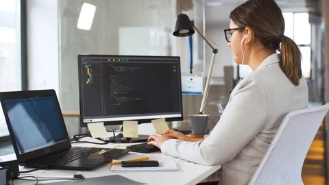 Programmer in earphones working on computer Stock Footage 106132474