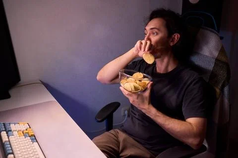 Programmer enjoying late night snack, Individual working alone in home office Stock Photos