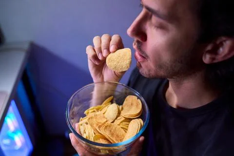 Programmer enjoying late night snack, Individual working alone in home office Foto stock