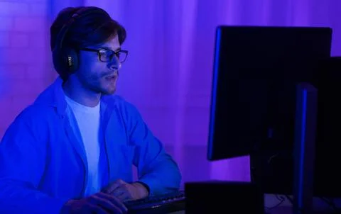 Programmer In Eyeglasses Coding On PC At Home, Low Light Stock-Fotos