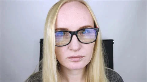 The programmer girl's glasses reflect moving lines of code. Programming, develop Stock Footage 138730693