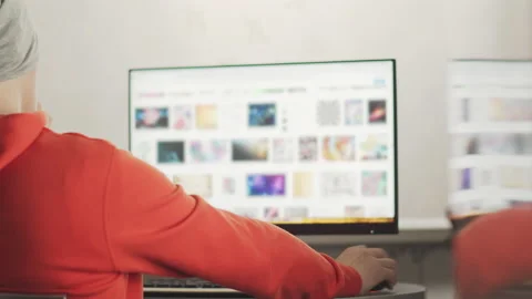 A programmer in a gray hat works in a home office in the evening sitting Stock Footage 154205849