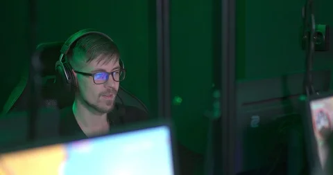 Programmer guy is sitting at the computer and is carefully looking at the Stock Footage 127011592